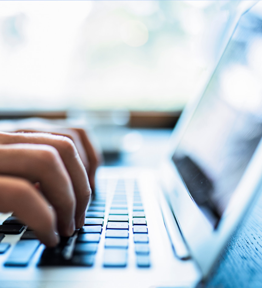 Person typing on laptop keyboard